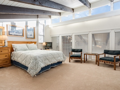 Unwind in your spacious bedroom, where natural light floods through skylights and large windows. Cozy linens invite restful nights, while a private seating area gives you room to relax.