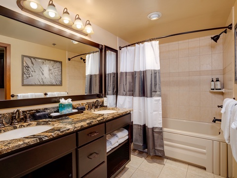 Unwind in your elegantly appointed bathroom featuring a deep soaking tub, granite countertops, and plush towels—your private retreat after a day of mountain adventures.