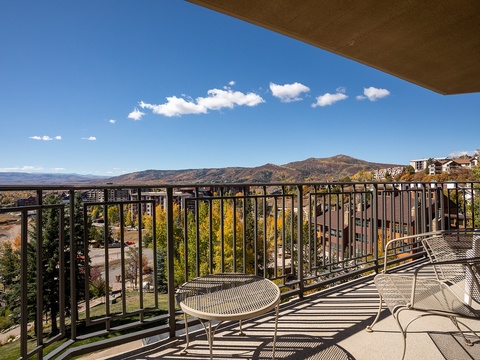 A spacious balcony offering sweeping views of mountains, autumn foliage, and the surrounding neighborhood. Sit back and enjoy sunny days overlooking colorful treetops and distant peaks.