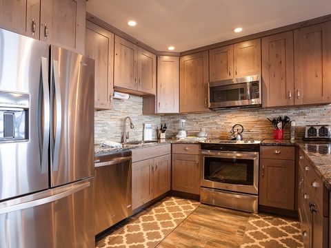 Your fully-equipped kitchen features stainless steel appliances, granite countertops, and warm wood cabinetry—perfect for preparing your favorite meals in comfort and style.