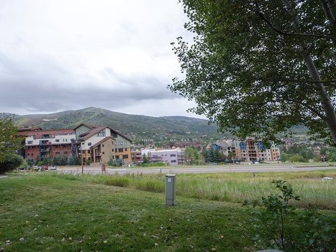 The property sits in a scenic mountain town, surrounded by peaks and forested hillsides with walkable access to local buildings and outdoor spaces.
