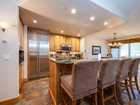 A fully-equipped kitchen with elegant countertops and stylish bar seating invites you to cook and share meals together in a warm, welcoming setting.