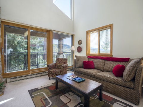 Relax in your bright living room with vaulted ceilings, plush seating, and sweeping mountain views through floor-to-ceiling windows. Unwind by the stone fireplace after a day exploring the surrounding beauty.