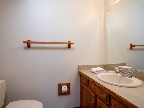 Your private bathroom features warm wood accents, a spacious vanity with fresh towels, and a convenient layout for your comfort.