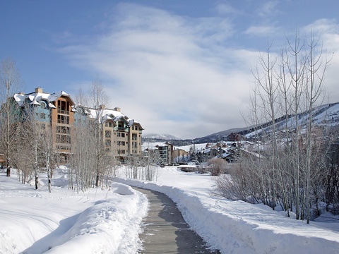 A pristine winter scene showcasing the property nestled in a scenic mountain valley, surrounded by snow-dusted trees and alpine peaks—part of the tranquil neighborhood awaiting your arrival.