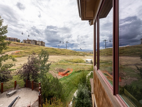 A ski resort property surrounded by rolling hills and scenic mountain terrain, with gondola access visible in the distance.