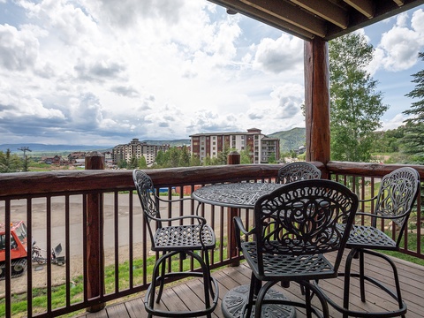 Relax on your private deck with morning coffee or evening drinks, taking in sweeping mountain and valley views framed by tall pines and dramatic skies.