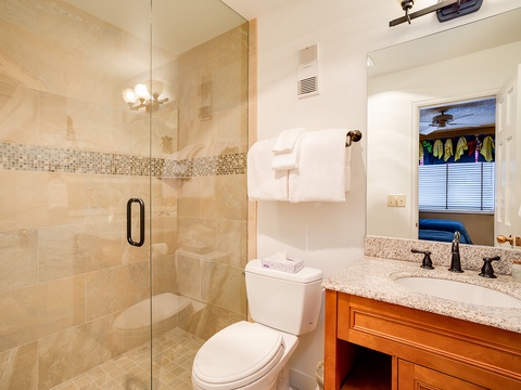 Unwind in your private bathroom featuring a spacious walk-in shower, granite countertops, and plush towels ready for your arrival.