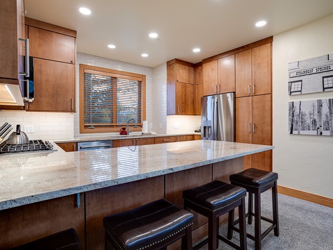 Picture yourself preparing meals at this spacious granite-topped island, with warm wood cabinetry and stainless appliances at your fingertips, ready for your mountain getaway culinary adventures.