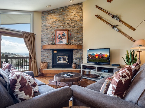 Cozy up by the stone fireplace in your living room, where mountain views frame a space designed for relaxation. Sink into plush seating after a day on the slopes.