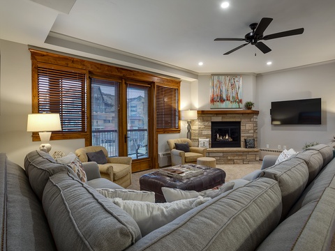 Curl up in this cozy living room with plush sectional seating, a warm stone fireplace, and ample space for your group to relax together after a day of adventure.