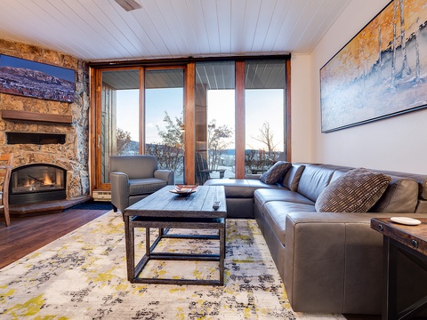 Sink into plush leather seating by your crackling stone fireplace, with floor-to-ceiling windows framing breathtaking mountain views that bring nature right to your doorstep.