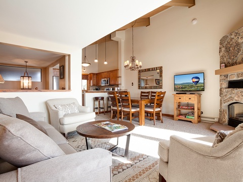 Relax in your bright, open living area with soaring ceilings, cozy stone fireplace, and plush seating perfect for gathering after a day of adventure.