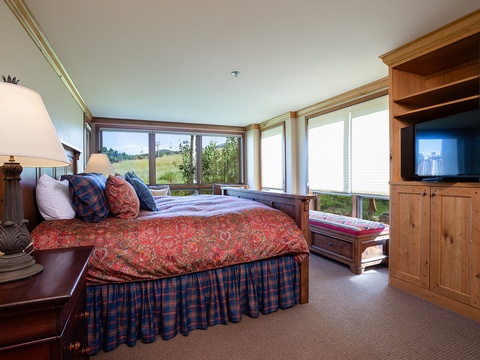 Wake up to sweeping meadow views through walls of windows. Your peaceful retreat features a plush bed, cozy seating, and entertainment center—all designed for ultimate relaxation.