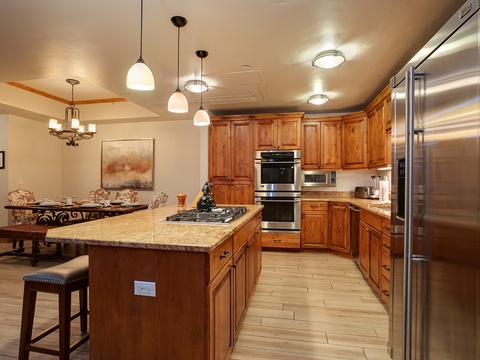Your gourmet kitchen features rich wood cabinetry, granite countertops, stainless-steel appliances, and a welcoming island—perfect for preparing memorable meals during your stay.
