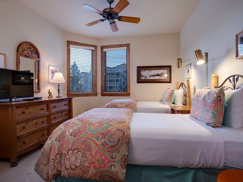 Sink into fresh white linens with cheerful paisley throws, relax with your favorite show, and enjoy the gentle breeze from the ceiling fan overhead.