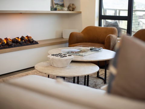 Curl up in a cozy chair beside the modern fireplace, where soft lighting and inviting textures create the perfect retreat for unwinding after your day of exploring.
