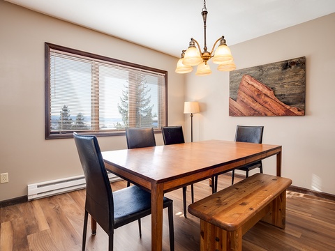 Gather around the dining table for meals bathed in natural light, with rustic mountain-inspired decor setting a cozy, inviting tone for your group.