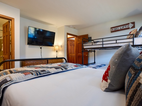 Your cozy mountain retreat features a comfortable queen bed, bunk beds for extra guests, and modern entertainment—perfect for unwinding after a day on the slopes.