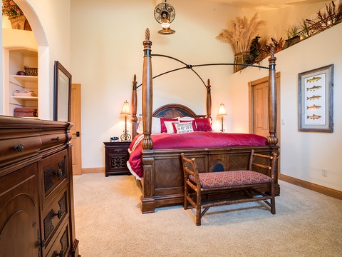Sink into this elegant four-poster bed with rich linens and rustic charm, surrounded by thoughtful touches like soft lighting and cozy seating—your perfect retreat after a day of adventure.