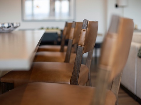 Gather around the spacious dining table where stylish leather chairs await your memorable meals together in this bright, modern space.