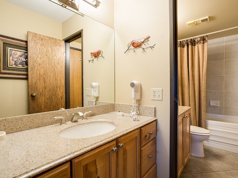 Your private bathroom features a spacious vanity with granite counters, wall-mounted hairdryers, and a separate tub-shower combo—perfect for freshening up after mountain adventures.