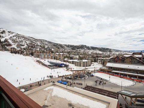 The property sits at the base of a snow-covered ski resort, offering direct access to slopes, lifts, and a vibrant village plaza surrounded by alpine scenery.