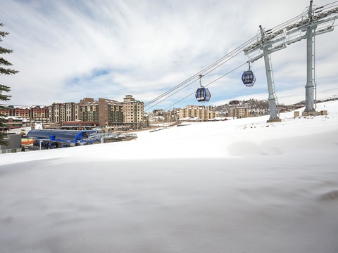 A ski resort village nestled in snowy mountains, with gondola lifts and modern lodges creating a winter wonderland arrival scene.