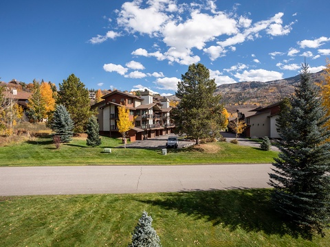 Mountain resort nestled among evergreens and golden aspens under crisp autumn skies, offering a peaceful retreat in a scenic alpine neighborhood.