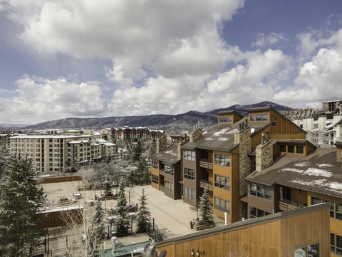 Alpine village with modern mountain lodges nestled against snow-dusted peaks, offering a serene winter retreat atmosphere.