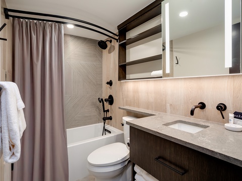 Refresh after your adventures in this sleek bathroom, where you'll enjoy a spacious tub-shower combo, modern fixtures, and thoughtful touches like plush towels and ample storage for your essentials.