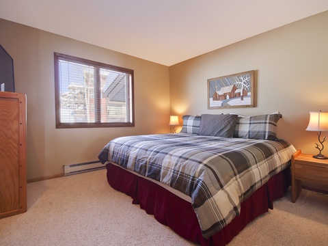 Unwind in your cozy bedroom with its plush plaid bedding, soft lighting, and warm mountain-inspired touches that make every evening feel like a peaceful retreat.