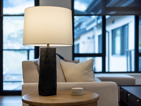 Settle into your inviting living space where natural light streams through floor-to-ceiling windows and a plush sofa invites you to unwind with a good book or simply soak in the peaceful ambiance.