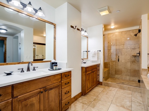 Your private bathroom offers dual vanities, elegant tile work, and a spacious glass-enclosed shower—perfect for refreshing after a day of mountain adventures.