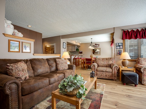 Sink into plush seating in your spacious living room, where warm wood accents and cozy furnishings create the perfect gathering spot for your mountain getaway.