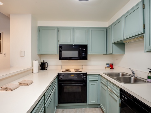 Bright kitchen with charming blue cabinets, full appliances, and ample counter space—perfect for preparing your favorite vacation meals.