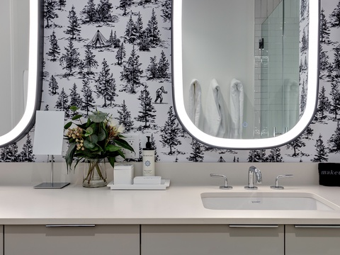 Step into your elegant bathroom sanctuary. Dual backlit mirrors frame a sleek vanity, while curated touches—fresh florals, soft towels, and bespoke toiletries—make your morning routine feel indulgent.