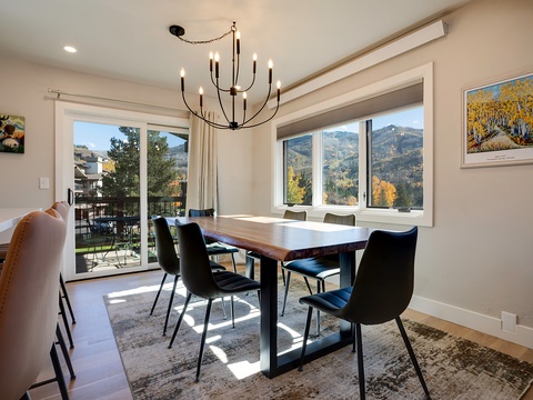 Gather around this elegant dining table with mountain views framing your meals, where natural light and autumn colors create the perfect backdrop for your memorable moments together.