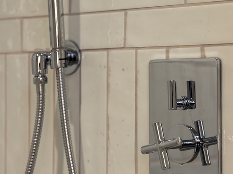 Rinse away the day under your sleek handheld shower with modern chrome fixtures and classic subway tile. Everything's within easy reach for a refreshing, hassle-free experience.