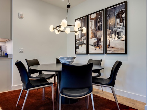 Gather around your stylish dining table for meals and conversation under a modern chandelier. The open layout connects you to the kitchen, making entertaining effortless.