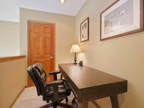Your private workspace with a sturdy desk, comfortable chair, and soft lamp light—perfect for catching up on emails or planning your next adventure.