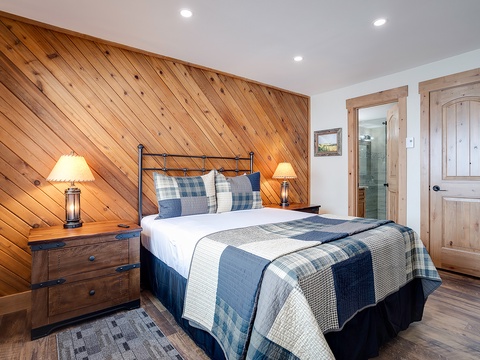 Relax in your cozy bedroom with rustic wood accents, plush bedding, and an ensuite bath—your peaceful retreat after a day exploring.