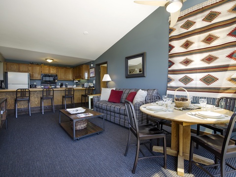 Gather around the cozy dining table or unwind on the plaid sofa in your open-concept retreat, where the fully equipped kitchen and Southwestern-inspired décor create the perfect space for your mountain getaway.