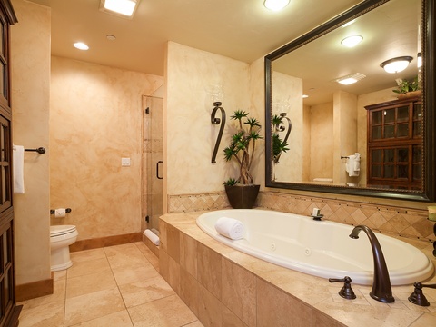 Unwind in your private spa-style bathroom with a deep soaking tub, separate walk-in shower, and warm, elegant finishes that invite total relaxation.