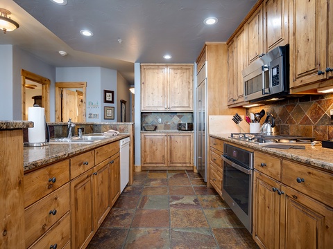 Your fully equipped mountain kitchen awaits with granite countertops, stainless appliances, and warm wood cabinetry. Whip up hearty breakfasts or après-ski dinners in this inviting space with everything you need.