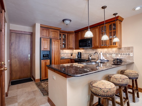 Your fully equipped kitchen welcomes you with elegant wood cabinetry, granite countertops, and a breakfast bar—perfect for preparing meals or enjoying morning coffee in comfort.
