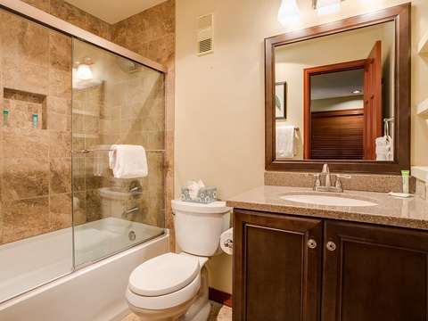 Your private bathroom offers elegant travertine tilework, a relaxing tub-shower combo, and plenty of counter space—designed for your comfort and convenience.