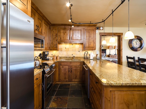 Your gourmet kitchen awaits with rich wood cabinetry, granite countertops, and stainless-steel appliances—perfect for preparing meals while soaking in the mountain-home charm.