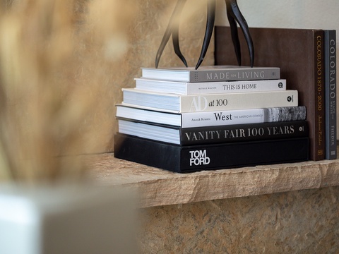 Thoughtfully curated design books rest on a floating wooden shelf, adding a touch of sophistication to your space. Perfect for your downtime reading.