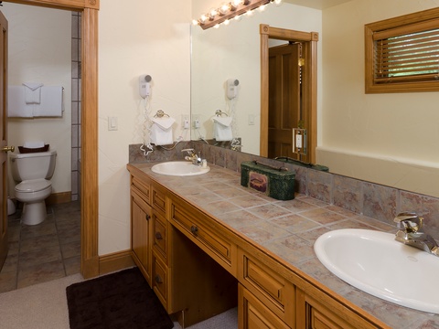 Refresh in your spacious double-vanity bathroom with plenty of counter space, warm wood cabinetry, and all the comforts you need for a relaxing getaway.